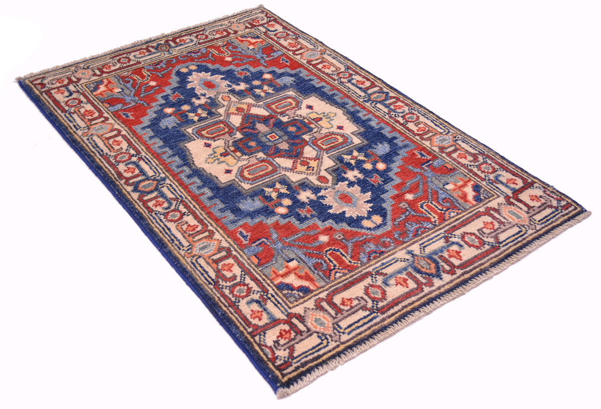 Geometric Kazak rug with blue, red, and cream field and ornate border, angled view.