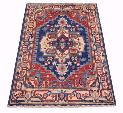 Heriz-style Kazak rug with central floral medallion in blue, red, and cream colors.