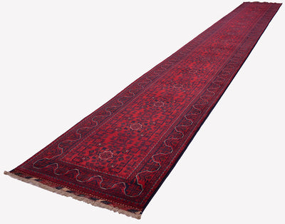 A long red oriental runner rug with dark blue and beige patterns, shown diagonally on a plain white background.