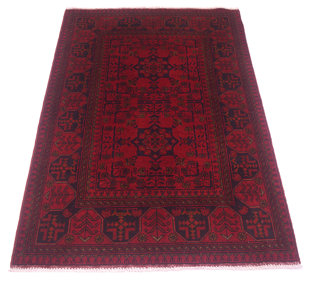 A traditional rectangular afghan area rug with a deep red field and dark navy blue borders and central medallion, shown flat against a white background.