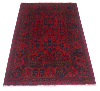 A traditional rectangular afghan area rug with a deep red field and dark navy blue borders and central medallion, shown flat against a white background.