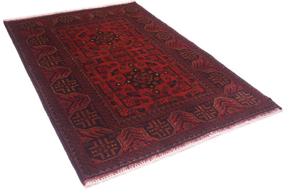 A traditional afghan-style wool area rug with a deep red field, dark navy borders, and intricate geometric patterns, shown from an elevated angle on a white background.