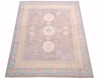 Overall of Afghan handmade Khotan design carpet with soft colours and traditional three medallion format and  semi geometric border. Soft grey ground field clours wiih powder bue, coral pink and green geometric border. Eastern design carpet shown on a white background. 