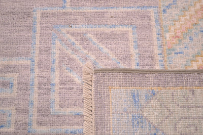 Reverse of Khotoan design carpet in grey, cream, green, gold and pink showing handknotting and cotton warp fringes. 