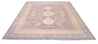 Over all view of pastel toned Khotan carpet handknotted in Afghanistan with natural vegetable dyes and handspun wool. Traditional antique Khotan design with three medallion moon guls. Powder blue border with light green and coral pink motifs.