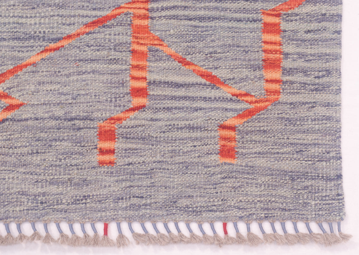 Close-up of a handwoven kintsugi design Kilim runner with a blue-grey base and bold rust-orange geometric stripes, finished with short fringe along the bottom edge.