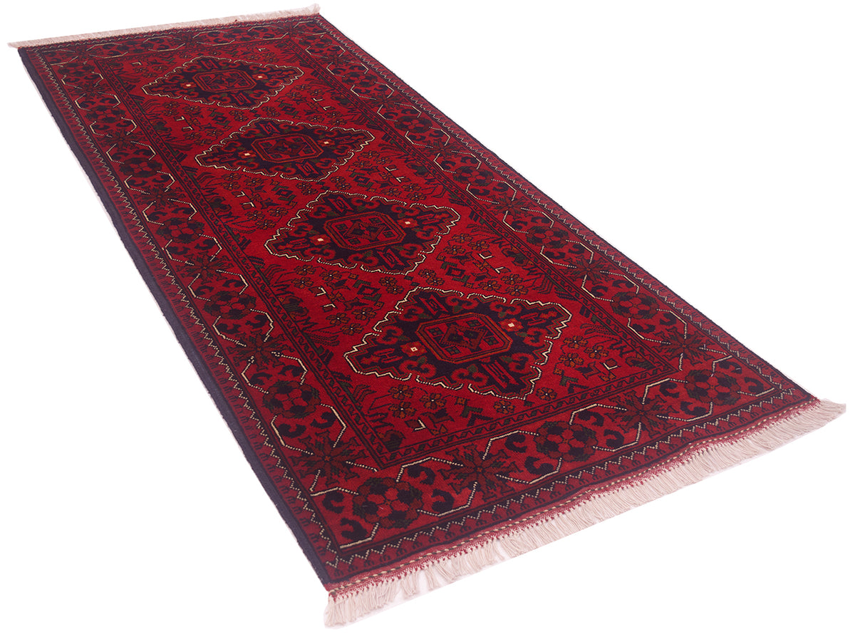 A  red afghan runner rug with dark navy blue borders and central medallions, detailed with gold and cream accents, shown on a plain white background.