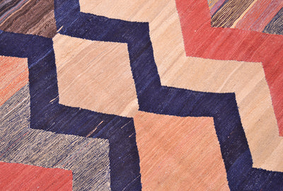 Close-up of kilim rug weave with navy, red, and cream geometric blocks