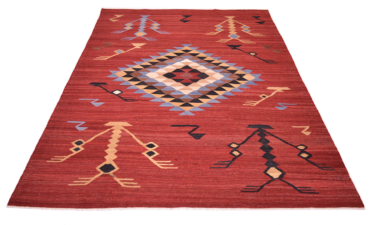 A rectangular red Labijar Afghan Kilim area rug with a geometric pattern, featuring a large central diamond and stylised figures in beige, black, blue, and brown.