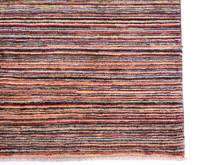 A close-up of a striped handmade Gabbeh rug with horizontal bands in rust orange, navy blue, charcoal grey, beige, and muted pink, finished with a fringed edge on a white background.