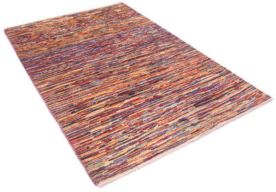 A rectangular modern stripy Gabbeh rug with a dense, textured horizontal stripe pattern in a multicolour mix of rust, orange, red, blue, purple, and beige tones, shown from an elevated perspective on a white background.