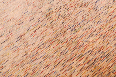 A close-up of a textured Afghan Gabbeh carpet with a warm beige base and dense, diagonal multicolour flecks in orange, red, blue, green, and brown.