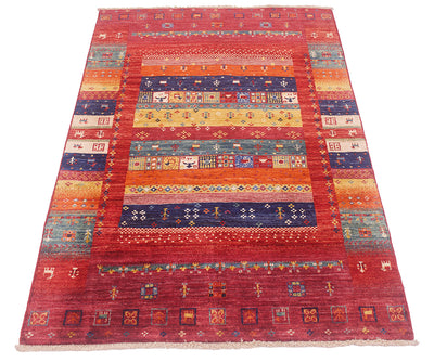 A 1.5x1m rectangular hand-woven Afghan Loribaft area rug with a complex geometric and tribal pattern, featuring a dominant red field with multiple coloured bands including blue, yellow, orange, and green.