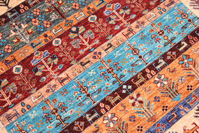 A close-up of a handmade patterned Afghan Loribaft area rug with multiple horizontal bands of geometric and floral motifs in rust red, turquoise blue, peach, navy, and cream.