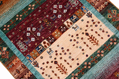 Handmade Afghan Loribaft Gabbeh rug shown diagonally, with turquoise border and cream central pattern