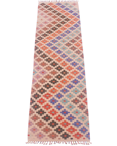 A 3m long rectangular woven Kilim hallway runner rug with a geometric diamond pattern in multiple colours, including pink, orange, blue, brown, and purple on a light beige background, finished with fringe on the top and bottom.