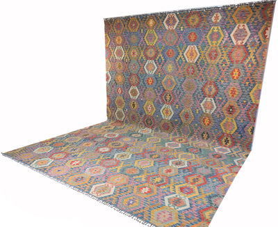 A Giant Handwoven Afghan Kilim rug with a geometric pattern, shown draped to display both its flat surface and its hanging wall form against a plain white background.