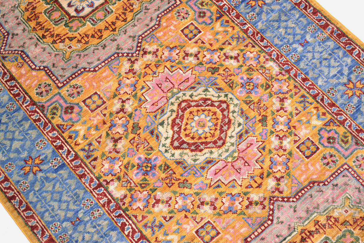 Detail of geometric medallion of fine afghan mamluk runner with pinks and gold yellow hues