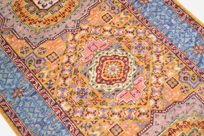 Detail of geometric medallion of fine afghan mamluk runner with pinks and gold yellow hues