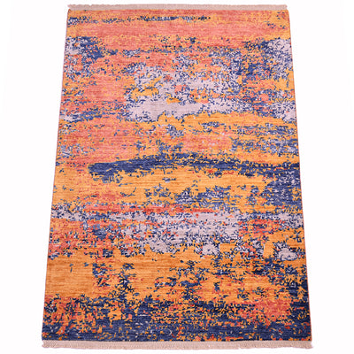 Overall view of Modern Afghan rug with mirage abstract design and array of fragmented colour patterns in light amber gold, coral terracotta, soft dove greys and deep sea blues. Lattice bound cotton fringe warps.