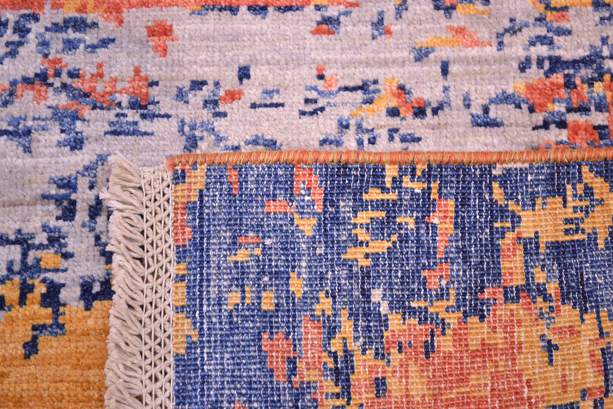 Reverse of abstract rug showing fine knotting and cotton warps  and lattice fringe. Handknotting and cotton warps. Close up of wool handknotted pile with soft greys.