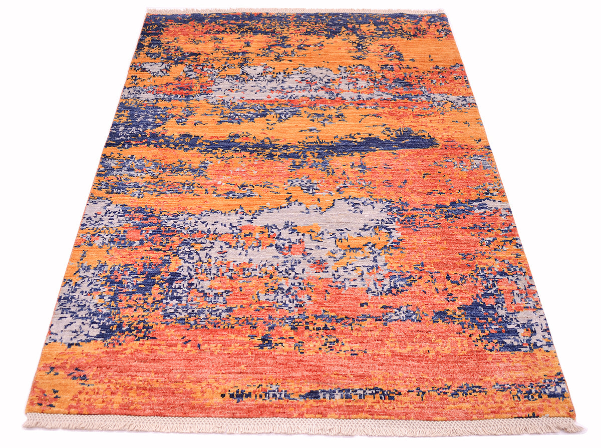 Overall view of abstract Afghan Rug hangknotted with a fragmented erosion design with soft coral terracota, light amber, light grey and deep blue handwoven wool pile with cotron latticesdwarp threads.