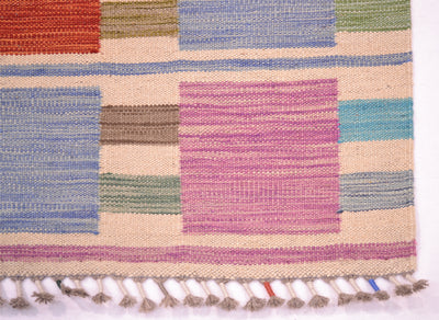 A close-up of a woven Modern Afghan Kilim runner with a geometric block pattern in colours including pink, blue, green, orange, and beige, finished with a fringed edge.