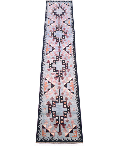 A 4m rectangular geometric Blue Aryana long runner rug with a Southwestern-style pattern, featuring a light blue base with black, terracotta orange, and pink motifs, bordered by black and white diamond patterns.