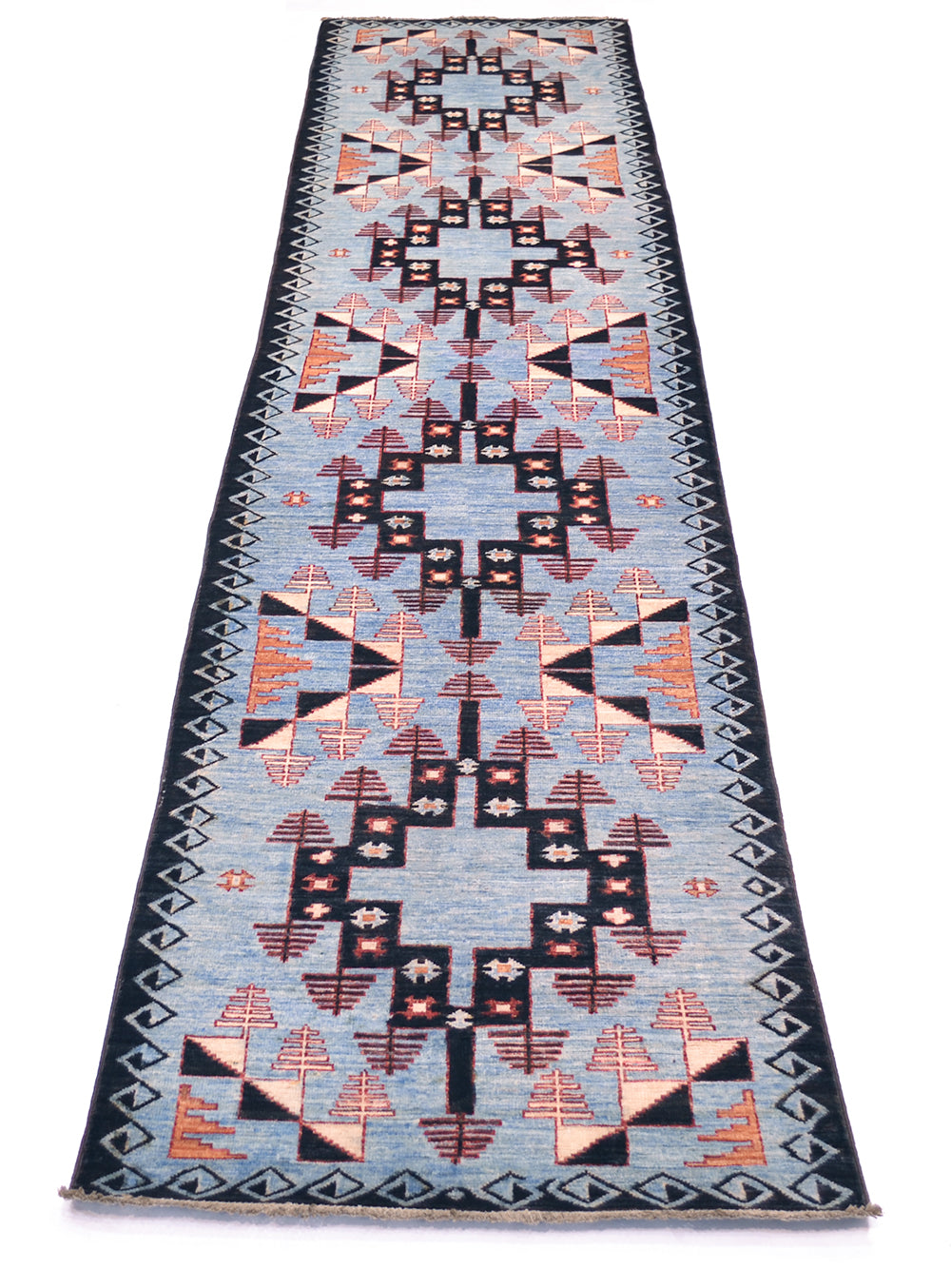 A rectangular Afghan blue Aryana long runner rug with a Southwestern geometric pattern, featuring a light blue centre field, black borders, and terracotta orange, beige, and white motifs.