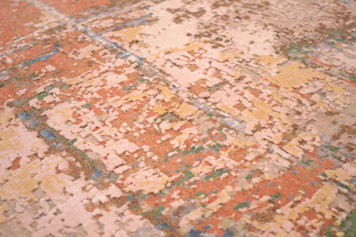 Close up detail of raised silk area in abstract modern Indian carpet with ligth pink/ coral/ white gold silk highlights. Handcut and textural as well as luminous silk.