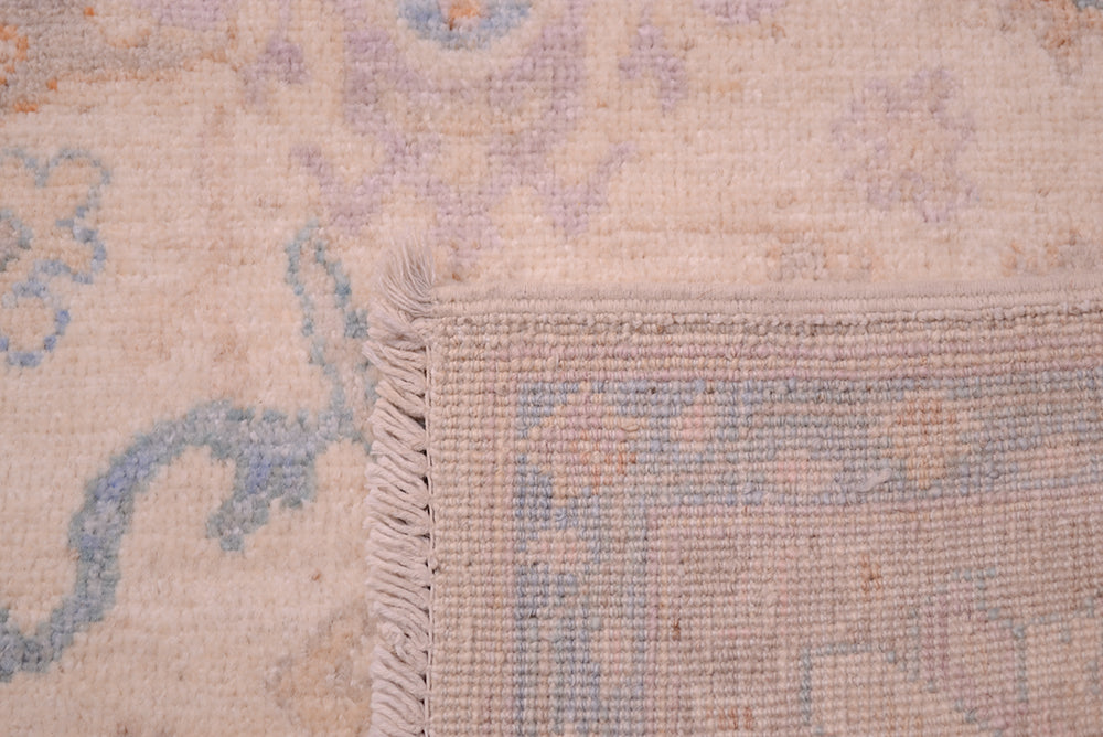 Reverse  of Pastel coloured  Oushak rug with back of knots and cotton warp fringe.