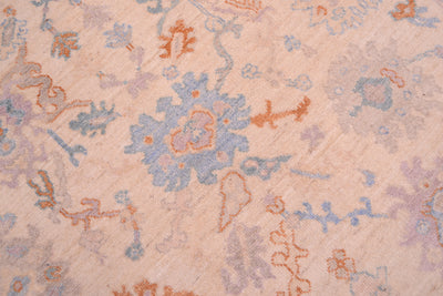 Detail of palmetts and Oushak motifs in central fields of hadnknotted carpet with terracotta and blues