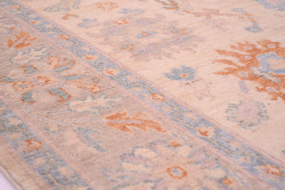 Detail of floral border in soft hues of terracotta  and blue of Afghan Ushak carpet.