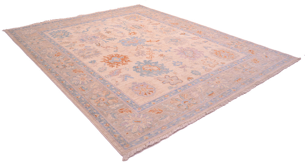 Angled view of Ushak inspired handmade carpet with mauve-grey border and all over floral design.