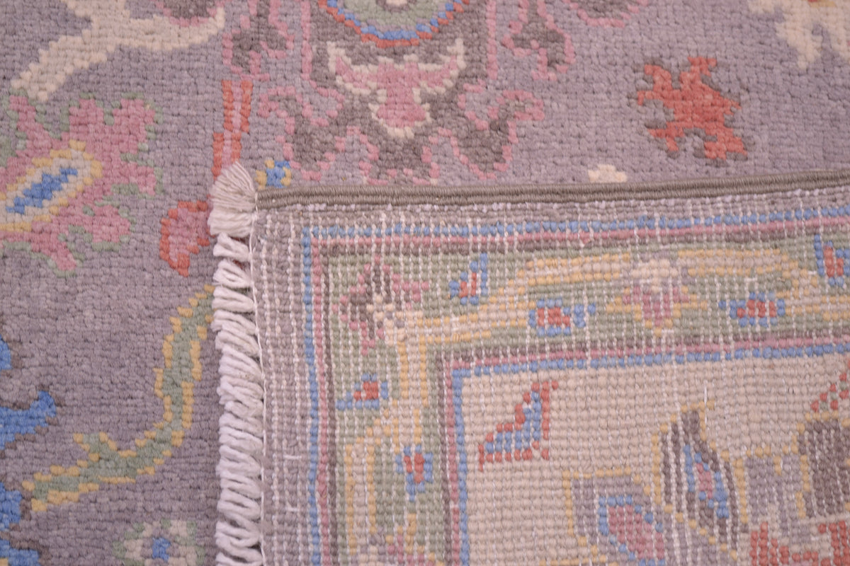 Detail of handknotted pile of field of grey and pastel toned Oushak Rug  and also reverse of rug showing knotting and weave.