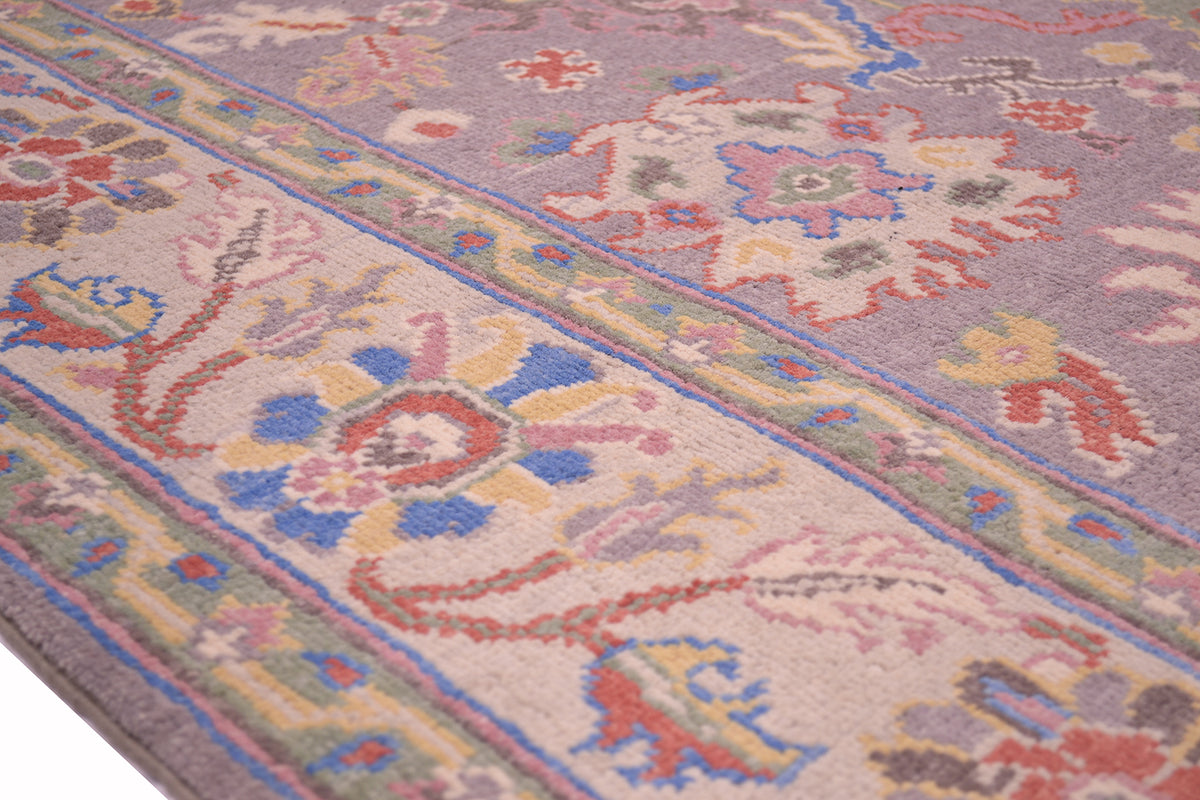 Floral border of grey Oushak carpet with light background  creamy  border and multiple pastel coloured palmettes and 