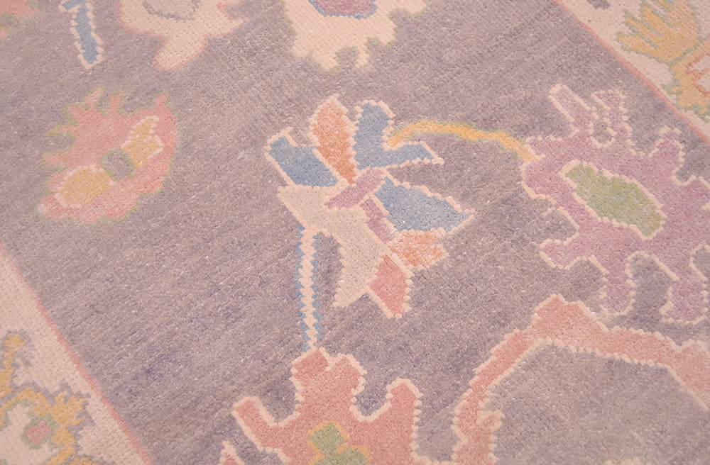 Detail of floral field of handmade runner with soft grey ground colour ans pastel palmettes