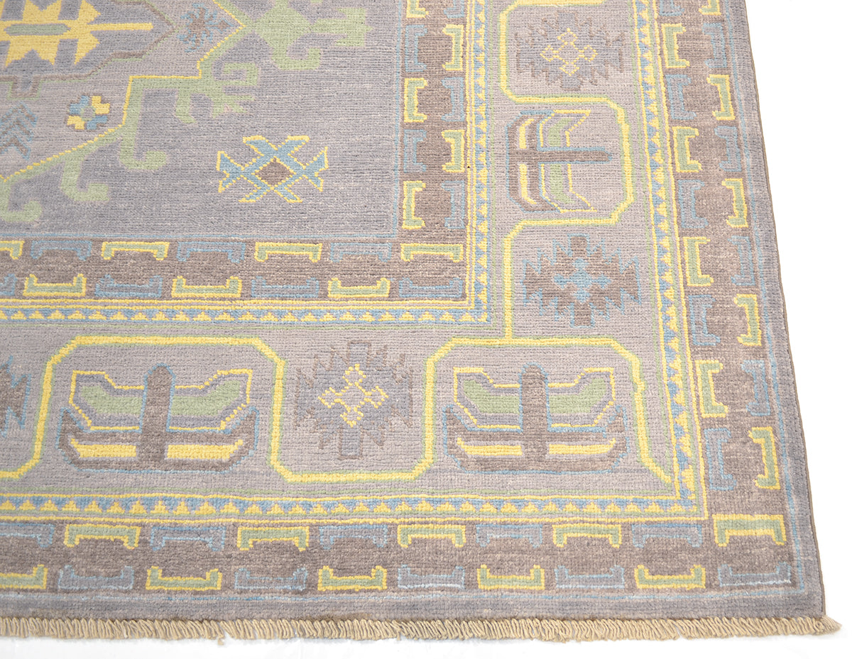 Border detail on grey Oushak carpet with repeating yellow cartouche motifs