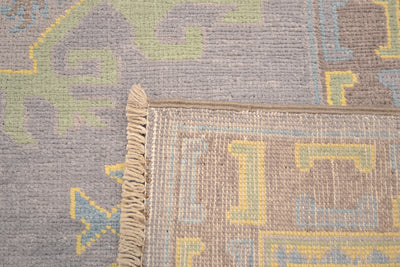 Corner fringe detail on grey Oushak carpet with yellow and blue pattern accents