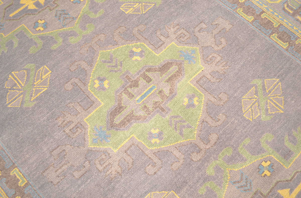 Close-up of grey Oushak carpet weave with yellow and light blue geometric motifs