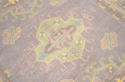 Close-up of grey Oushak carpet weave with yellow and light blue geometric motifs