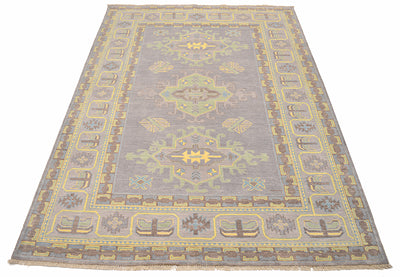 Grey Oushak carpet with centered medallion, framed by yellow ornamental border
