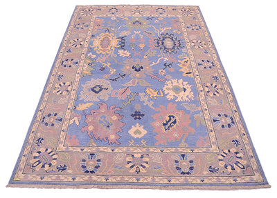 Handwoven ushak carpet with blue, grey and lilac hues.