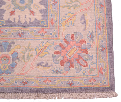 Corner detail and cotton fringe of handwoven Oushak carpet in soft colours