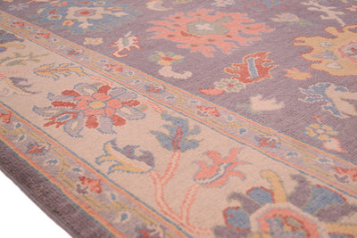 Detail of handwoven carpet cream and multicolour border in soft pastel hues.
