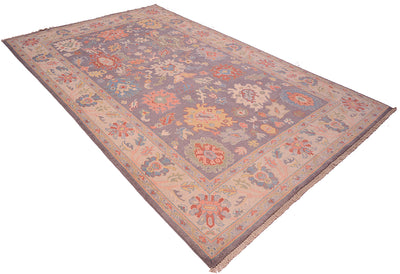 Angle view of Oushak design carpet in pastels and grey tones