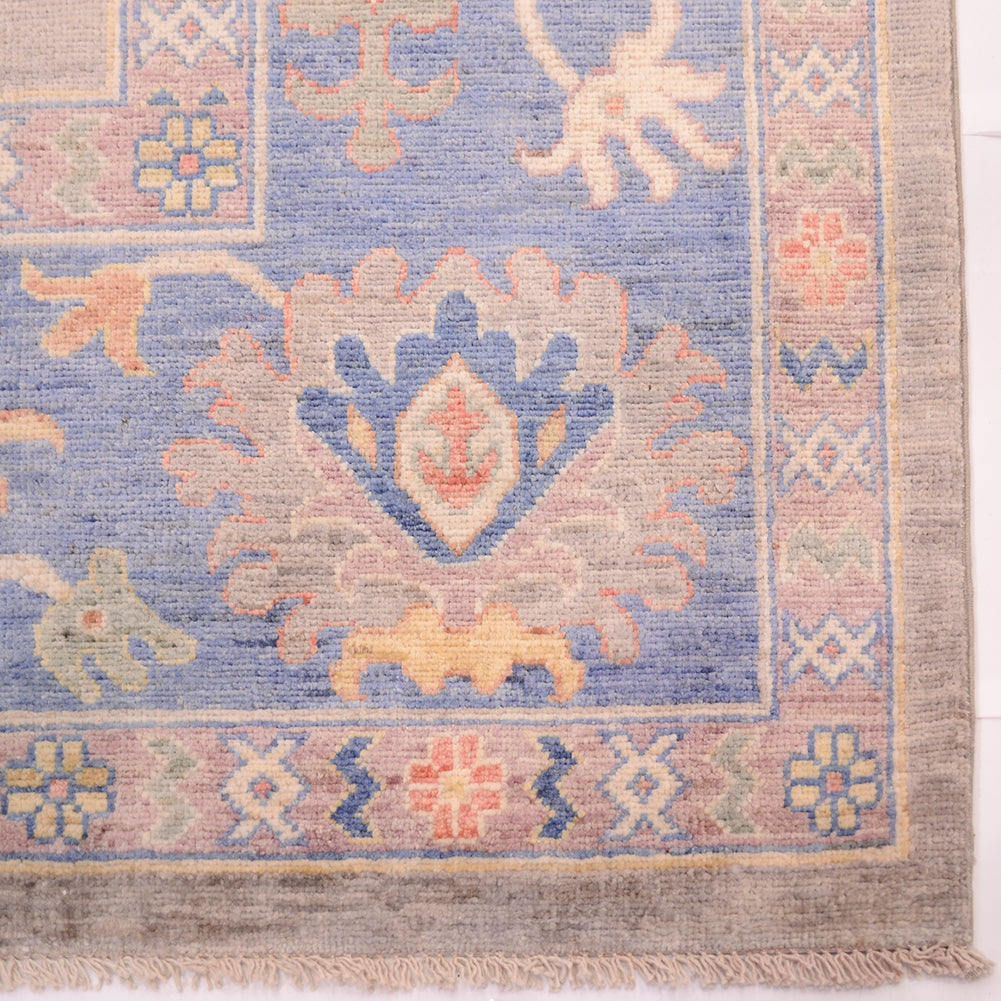 Corner detailing of large handmade carpet with blue border