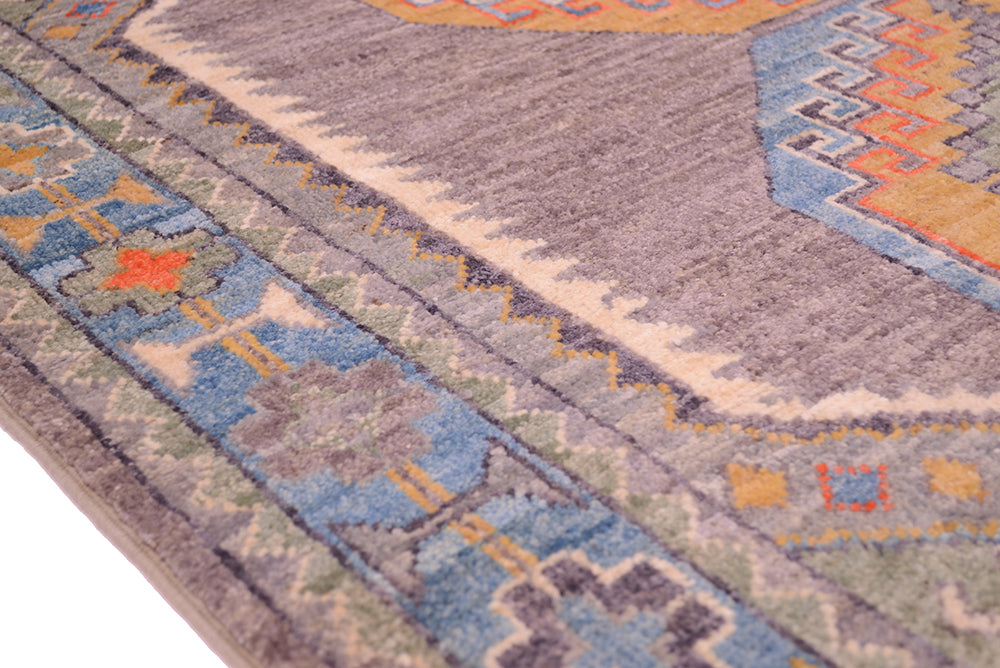 Details of geometric rosette border in blue of Afghan Oushak rug