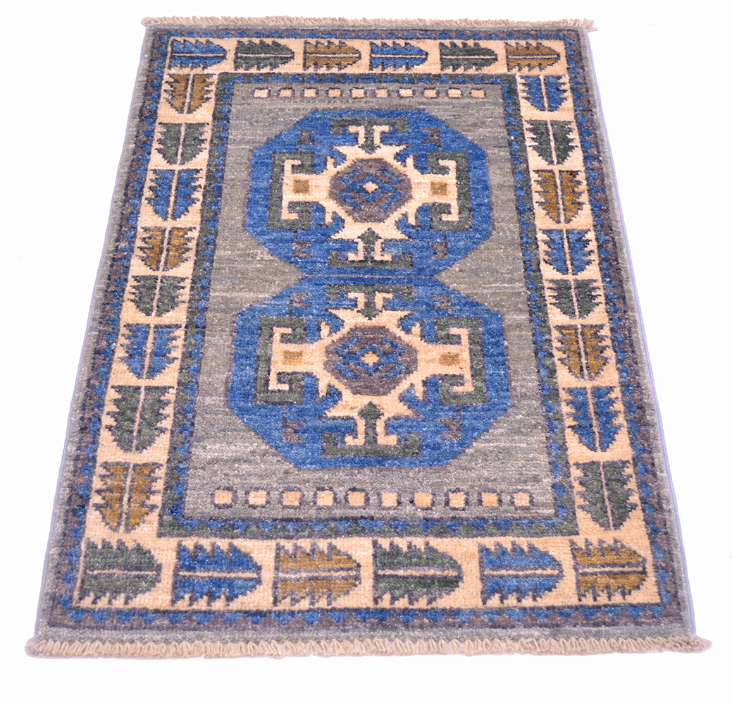Handknotted mat in blue, grey, cream , amber and green.