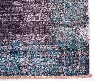 Corner detail of hallway vintage runner in aubergine and pertrol blues. Plain field colour of deep purple-aubergine with border in teal green blue with taditonal boteh design. Cotton warp fringes,
